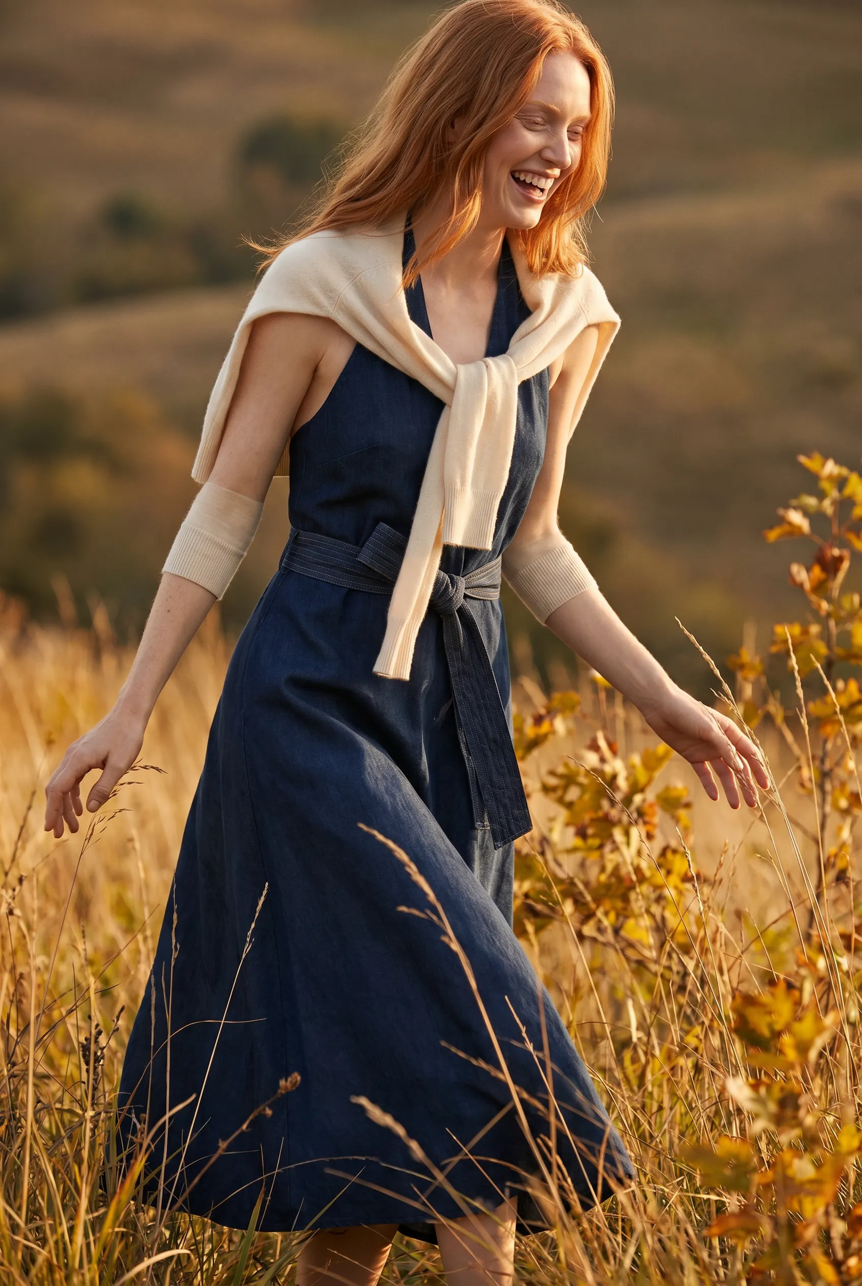 Editorial lookbook page: a golden-hour autumn field look in a navy wrap dress with a cream knit tied over the shoulders, generated with Alovia